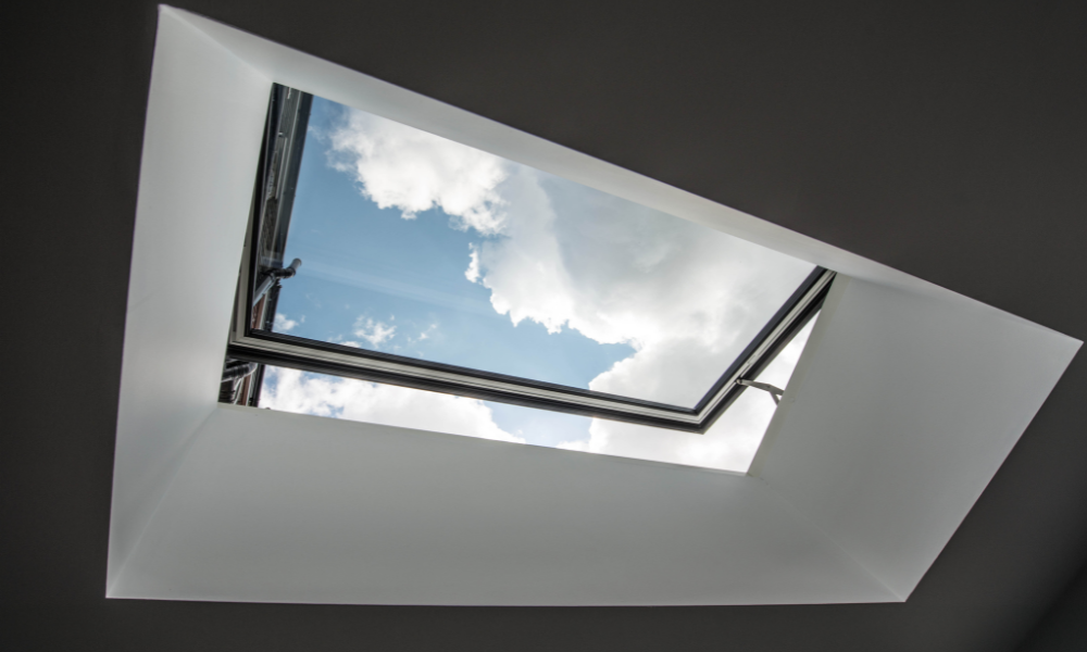 Visionvent skylight opened, looking from inside at the blue sky; installed for ventilation and natural daylight.