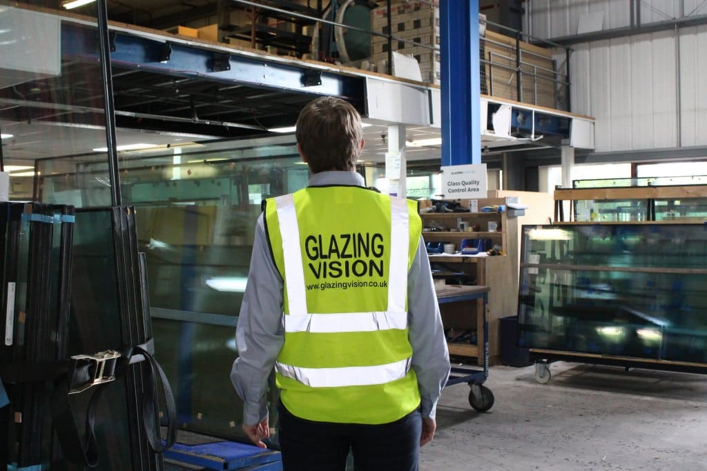 man standing in hi-viz looking at glass samples